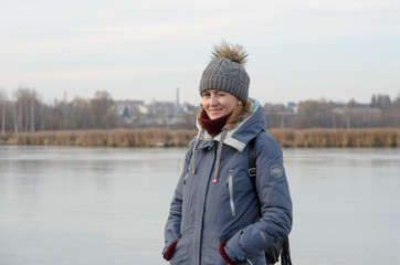 Pretty girl having fun on the winter lake, waving hair, smiling. Snowy mountains and blue sky on...
