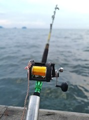 Multiplier fishing reel by the boat on ocean background