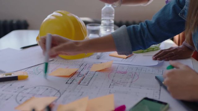 close up architects using building plans business women working together on construction project team of engineers brainstorming design solution planning successful development strategy