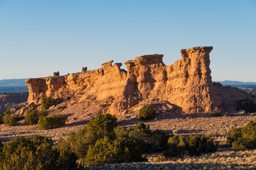 Fototapeta na wymiar Sandstone red rock formation glowing in the golden light of sunset near Santa Fe, New Mexico