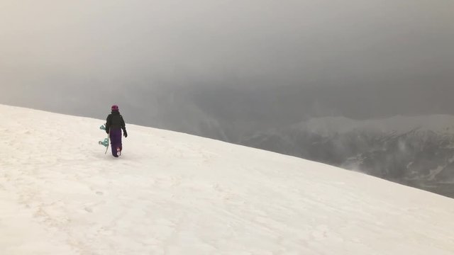 stormy sky winter time gudauri ski resort mountain top girl with a snowboard panorama 4k georgia
