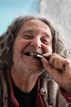 Happy senior man biting piece of chocolate