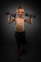 Fototapeta na wymiar Little Boy Lifting Weights