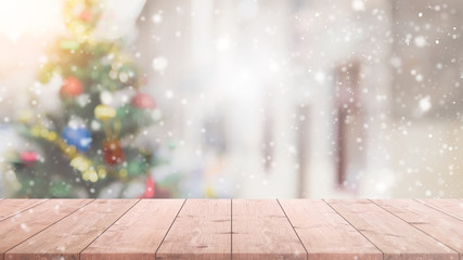Empty wood table top on blur with bokeh Christmas tree background with snowfall - can be used for...