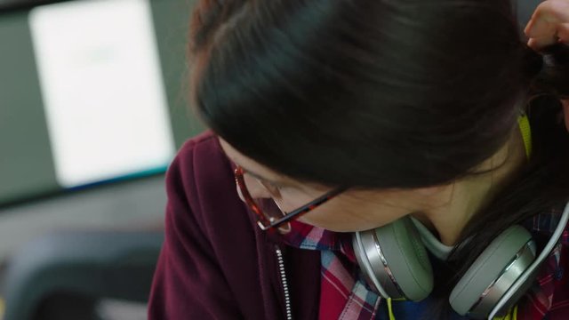 close up portrait young caucasian woman student using laptop computer browsing online  reading digital email on screen bored looking intern wearing glasses in office