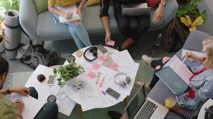 young engineers developing fitness app software using digital tablet computer brainstorming design solution sharing ideas in startup office meeting top view