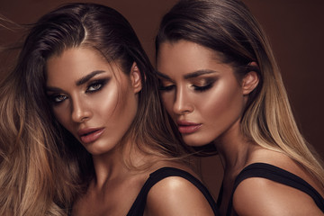 Two attractive twins women in glamour makeup - obrazy, fototapety, plakaty