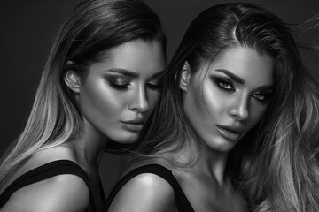 Naklejka premium Two attractive twins women in glamour makeup