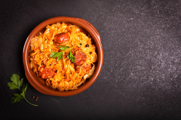 Bigos, a traditional Polish dish with cabbage on dark background with copy space