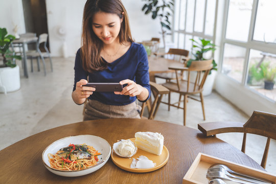 Happy woman take pictures of her food in coffee cafe shop in her chilling holiday
