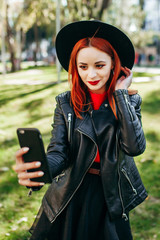 Close up portrait of a young stylish woman holding a smartphone