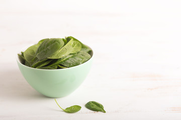 Washed fresh mini spinach in a bowl on the white table