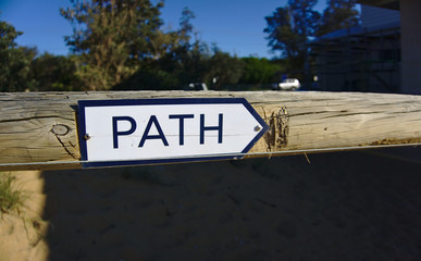 Path sign on wooden gate pointing to the right