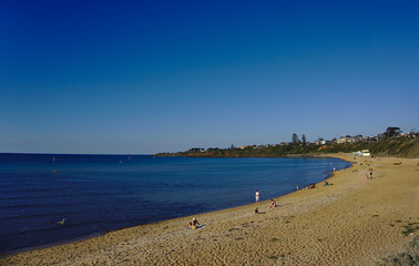 Distant view of people relaxing by the beach