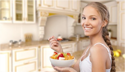 Attracive young woman enjoying fruits on breakfast