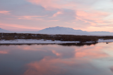 Fototapeta na wymiar Mountain in the winter being reflected on lake surface