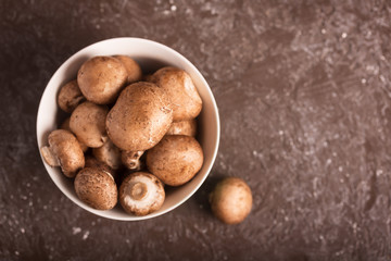 Portabello mushrooms in a green bowl on a dark background