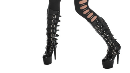 Sexy female legs in stockings and shiny black fetish high-heeled boots, isolated on white