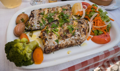 Delicious plate of typical portuguese fish served with vegetables and salad in Algarve, southern Portugal. Largehead hairtail fish / Peixe espada