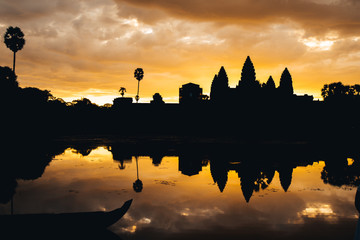 Fototapeta na wymiar Golden sky form Sunrise view of ancient temple complex at entrance of Angkor Wat in Siem Reap, Cambodia the World Heritage (one of Seven Wonders of the Word).
