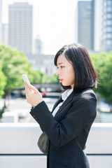 Fototapeta premium スマートフォンを持ったビジネスウーマン