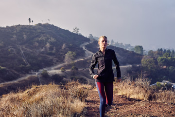 Fototapeta premium Beautiful Caucasian White Woman Runs on a Trail in the Morning Sunlight