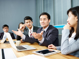 asian business man talking at negotiation table