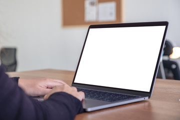 Mockup image of hands using and typing on laptop with blank white desktop screen while sitting in office