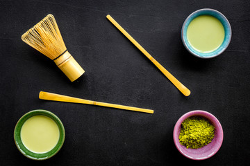 Fototapeta na wymiar Brew matcha green tea. Matcha powder, ready matcha tea, whisk on black background top view