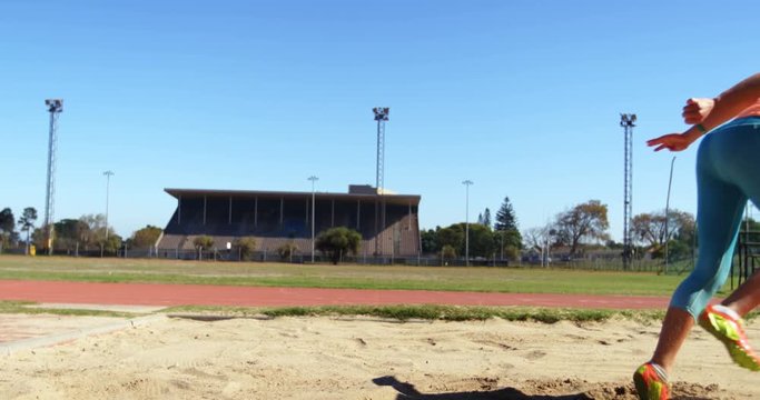 Female athlete practicing long jump at sports venue 4k