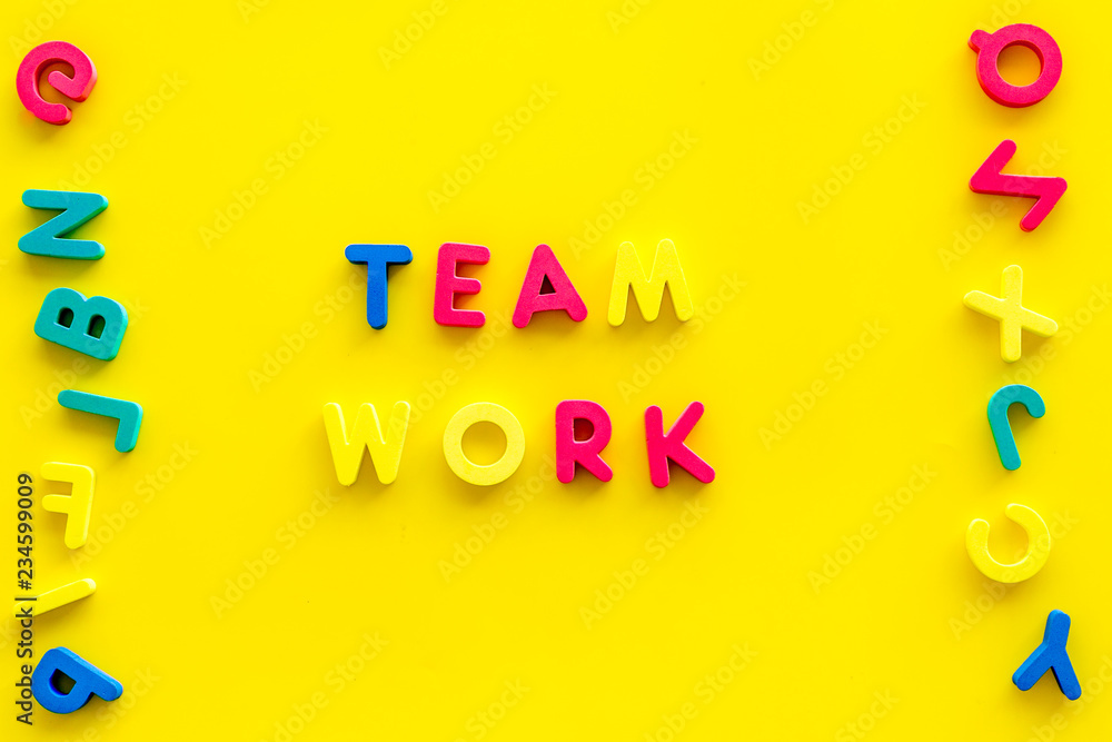 Aufkleber teamwork training concept. text teamwork lined with colored letters near toy letters on yellow backg