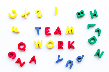 Teamwork training concept. Text teamwork lined with colored letters in frame of toy letters on white background top view