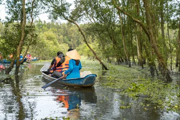 Foto op Canvas Tourism rowing boat in cajuput forest in floating water season in Mekong delta, Vietnam © Hanoi Photography