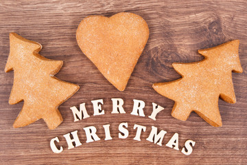 Inscription Merry Christmas with homemade gingerbreads and cookies for festive time