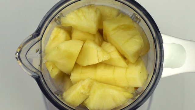 Top view of pineapple in blender, slow motion
