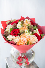 Bouquet of fresh spring flowers on gray wall background. Floral bunch in glass vase. flower shop, florist work