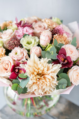 Bouquet of fresh spring flowers on gray wall background. Floral bunch in glass vase. flower shop, florist work