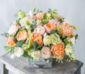 Bouquet of fresh spring flowers on gray wall background. Floral arrangement in vintage metal vase....