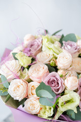 Bouquet of fresh spring flowers on gray wall background. Floral bunch in glass vase. flower shop, florist work