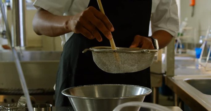 Chef staining white flour into metal bowl at restaurant 4k