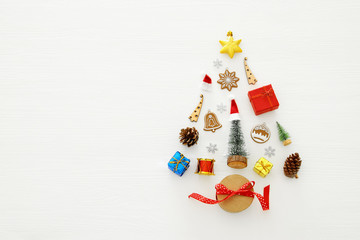 Top view image of festive decorations in shape of christmas tree over white wooden background. Flat lay.