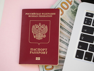 passport and money and laptop, pink background
