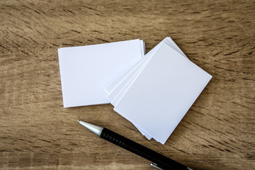 stacking of mockup empty white business card with elegance pen  on a wooden background , template for business  branding identity design