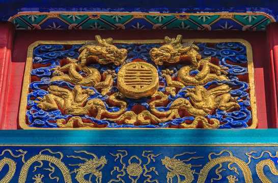 Ornate carved and painted beam and rafters with traditional Chinese dragon designs in Buddhist Yong'An (Temple of Everlasting Peace) in Beihai Park, Beijing, China