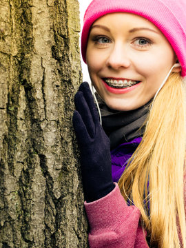 Woman wearing sportswear hugging tree