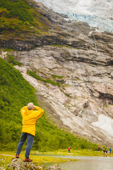 Tourist admiring Boyabreen Glacier in Norway