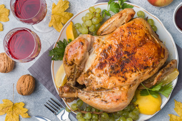 Baked chicken, mashed potatoes and wine glasses for dinner on the festive table.