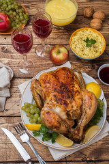 Baked chicken, mashed potatoes and wine glasses for dinner on the festive table.