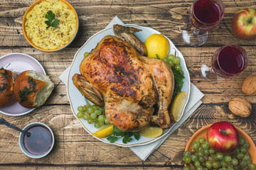 Baked chicken, mashed potatoes and wine glasses for dinner on the festive table.