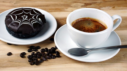 Americano or espresso coffee on the wood table with roasted coffee beans